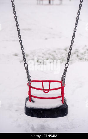 Neige sur swing siège dans une aire de jeux pour enfants Banque D'Images