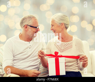 Happy senior couple with gift box à la maison Banque D'Images