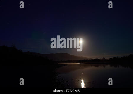 Pleine lune rivière paysage de nuit entouré de montagnes Banque D'Images