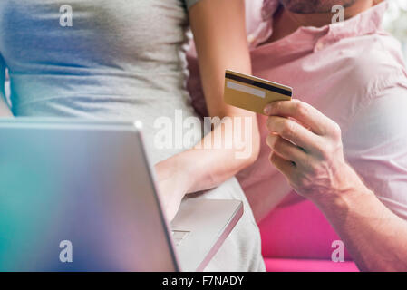 Couple à l'aide d'un ordinateur portable et une carte de crédit pour faire des achats en ligne, cropped Banque D'Images