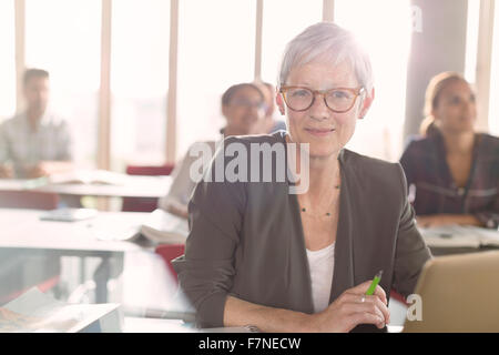 Portrait of smiling senior woman at laptop en classe d'éducation des adultes Banque D'Images