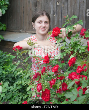 Young smiling girl fleuristes travaillant dans le jardin Banque D'Images