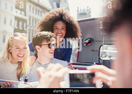 Amis enthousiastes photographiée sur bus double étage Banque D'Images