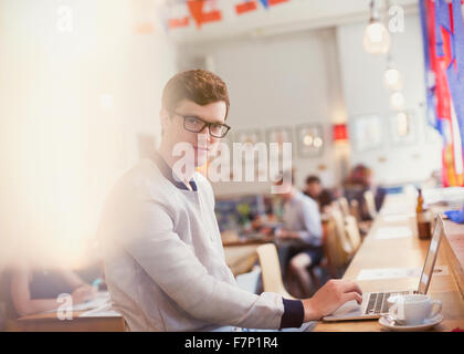 Portrait man using laptop in cafe Banque D'Images