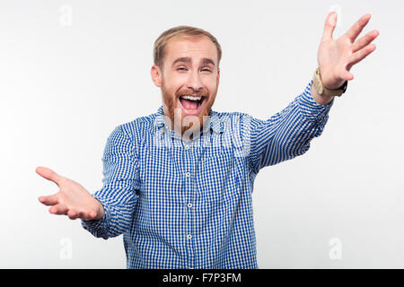 Portrait of a cheerful casual man montrant le geste de souhaits isolé sur fond blanc Banque D'Images