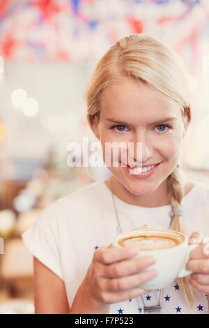 Close up portrait of blonde woman drinking cappuccino Banque D'Images
