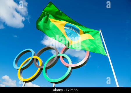 Londres, Royaume-Uni - Octobre 14, 2015 : drapeau brésilien vole à côté d'anneaux olympiques le comité permanent dans le parc Queen Elizabeth Olympic Park. Banque D'Images