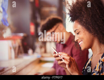 Smiling woman texting with cell phone Banque D'Images