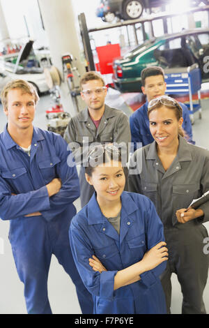 Portrait smiling mechanics in auto repair shop Banque D'Images