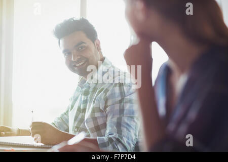 Smiling students parler en classe d'éducation des adultes Banque D'Images