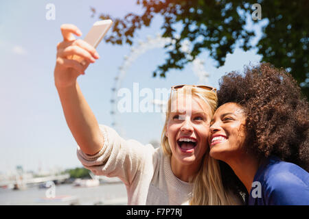 Les amis de prendre avec selfies London Eye en arrière-plan, Londres, Royaume-Uni Banque D'Images