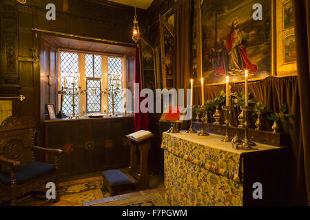 La chapelle de Baddesley Clinton, Warwickshire, à la chandelle, en regardant vers l'autel. Le prix a été créé dans sa forme actuelle par Thomas Ferrers en 1940, basé sur des photos de 1875. Peinture le retable, LE CHRIST AU Jardin de Gethsémani, par Rebecc Banque D'Images