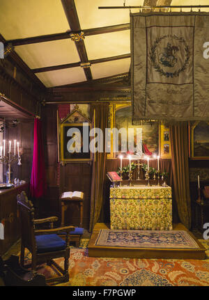 La chapelle de Baddesley Clinton, Warwickshire, à la chandelle, en regardant vers l'autel. Le prix a été créé dans sa forme actuelle par Thomas Ferrers en 1940, basé sur des photos de 1875. Peinture le retable, LE CHRIST AU Jardin de Gethsémani, par Rebecc Banque D'Images