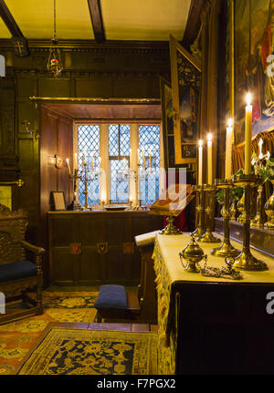 La chapelle de Baddesley Clinton, Warwickshire, à la chandelle, en regardant vers l'autel. Le prix a été créé dans sa forme actuelle par Thomas Ferrers en 1940, basé sur des photos de 1875. Peinture le retable, LE CHRIST AU Jardin de Gethsémani, par Rebecc Banque D'Images