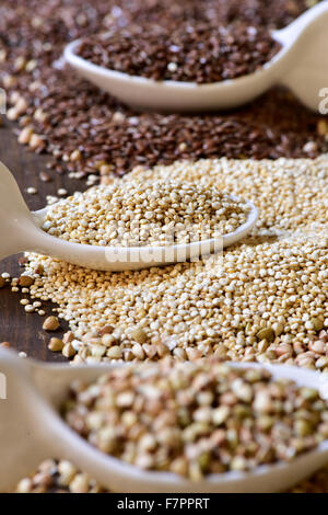 Libre de quelques cuillères en céramique avec différentes graines comestibles sur une surface en bois rustique, avec l'accent mis dans le les graines de quinoa, en th Banque D'Images