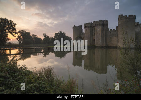 Château de Bodiam, East Sussex, reflétée dans les douves à l'aube. Banque D'Images