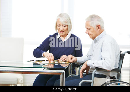 Happy senior couple jouer aux dames dans la maison de soins infirmiers Banque D'Images