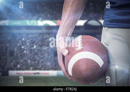 Image composite du milieu des sports player holding ball Banque D'Images