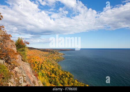 Haut Michigan robuste de la rive en couleurs de l'automne d'atteindre dans le lac Supérieur. Nuages spectaculaires avec copie espace dans le ciel et l'eau. Banque D'Images