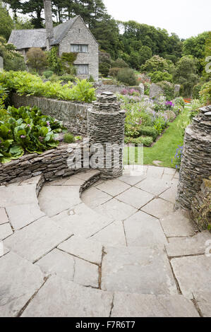 Panneaux bords du petit ruisseau de jardin, planté de fleurs aux couleurs pastel, à Coleton Fishacre, Devon. Le jardin de Coleton Fishacre est dans une vallée tumbling avec diverses et exotiques la plantation jusqu'à la mer. Banque D'Images