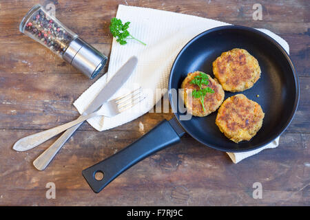 Burger (côtelette) dans la poêle. Burger (côtelette) dans la poêle sur la table en bois Banque D'Images