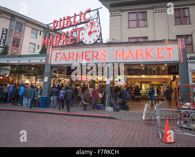 Seattle, Washington, USA. 23 Nov, 2015. Seattle's Pike Place Market a commencé en 1907 et a été conçu pour aider les petits agriculteurs et pêcheurs ainsi que les décideurs des autres marchandises. Le marché de Pike Place situé le long de la Seattle Waterfront le long de la baie Elliott et est composé de pas le long de Pike Place, une rue de la ville, mais aussi plusieurs étages en-dessous. Le Pike Place Market a subi quelques changements au fil des ans, mais a conservé son charme du vieux monde réunissant les touristes de partout dans le monde. ------- Sur la photo, une grande enseigne lumineuse à côté d'un grand réveil annonce l'entrée de Pike Place Market Banque D'Images