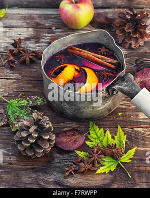 La sangria dans un vieux chapeau melon sur fond parsemé de feuilles d'automne et les cônes. Banque D'Images