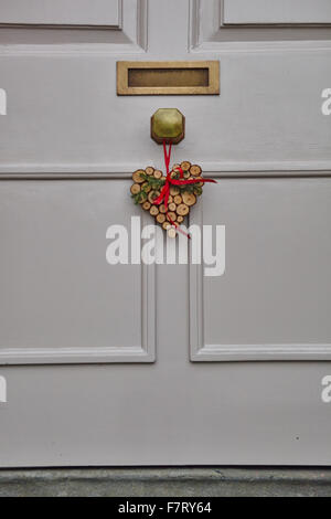 Couronne de Noël en forme de coeur sur porte avant blanc Banque D'Images