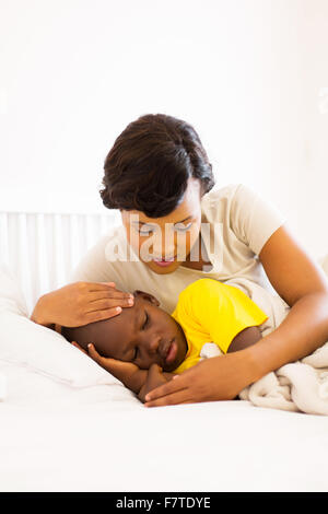 Aimer African American mother contrôle la température de son fils Banque D'Images