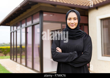 Belle Middle Eastern woman debout devant sa maison Banque D'Images