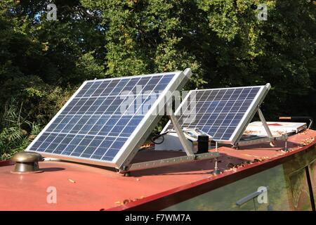 Des panneaux solaires sur le toit d'un grand classique à côté du chemin de halage sur le canal d'Oxford à Shipton on Cherwell Oxfordshire Banque D'Images