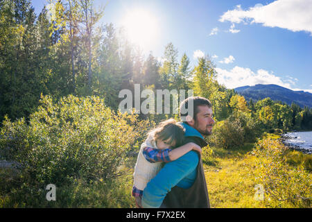 Father giving daughter un piggyback ride Banque D'Images