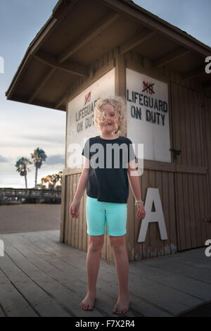 Girl standing in front of a lifeguard station Banque D'Images