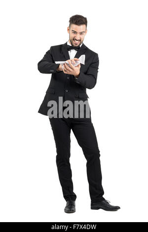 L'homme furieux en fonction de l'enfoncement du papier du contrat avec ses mains. La pleine longueur du corps portrait studio isolated over white background Banque D'Images