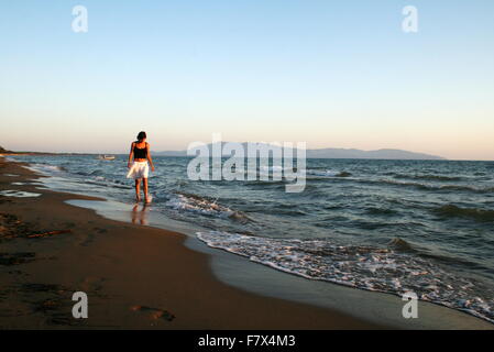 Femme marche sur la plage, Orbetello, Toscane, Italie Banque D'Images