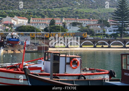 Cape Town Metrorail train qui passait juste derrière les bateaux de pêche au port de Kalk Bay Afrique du Sud Banque D'Images