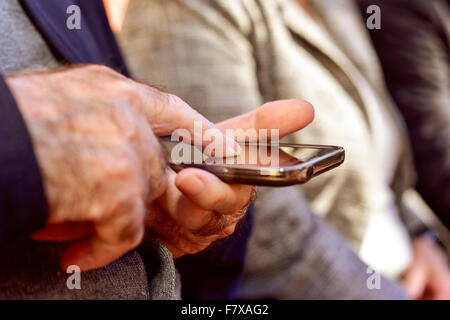 Libre d'un vieil homme de race blanche à l'aide d'un smartphone outdoors Banque D'Images