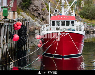 Bateau de pêche rouge amarré par une jetée à Sorvagen sur les îles Lofoten en Norvège Banque D'Images