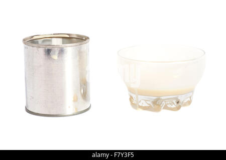 Lait condensé avec le sucre dans un bol en verre et étain pouvez isolated on white Banque D'Images