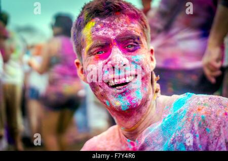 Un jeune homme couvert de poudre de couleur sourit pendant le Festival des couleurs Holi au Sri Sri Radha Krishna Temple le 29 mars 2014 à Spanish Fork, Utah. Le festival suit la tradition indienne de Holi et attire plus de 80 000 personnes. Banque D'Images