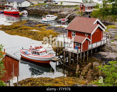 Petite maison sur pilotis et le petit bateau de pêche amarré à quai à Moskenes dans l'ouest des Lofoten, Norvège Banque D'Images