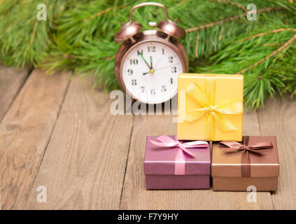 Boîtes cadeaux avec sapin et de l'horloge sur fond de bois Banque D'Images