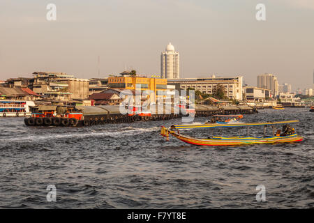 Un bateau longtail thaïlandais et d'une grande barge sur l'horizon de Bangkok vu de la rivière Chao Phraya Banque D'Images