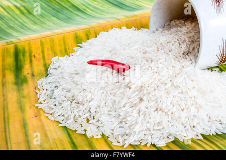 Sur une feuille de bananier se trouve riz non cuit et une tasse de café et un poivre Banque D'Images