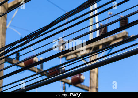 Gros plan d'une partie de l'électricité haute tension les câbles sur le ciel bleu Banque D'Images