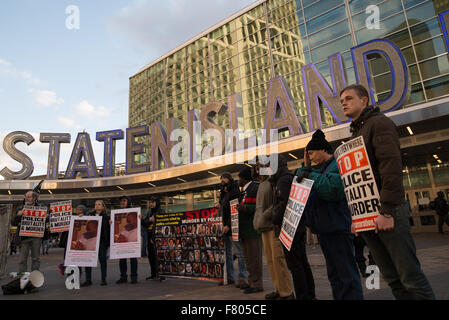 New York, États-Unis. 06Th Dec, 2015. Un groupe de manifestants tenir signe en ralliant l'extérieur du terminal de ferry de Staten Island à Manhattan. Une confédération de militants de l'arrêt de l'incarcération de masse et Réseau Occupy Wall Street, entre autres, organisé une protestation de l'arrondissement à l'occasion de l'anniversaire du refus par un grand jury de Staten Island pour charger le NYPD officer Daniel Pantaleo avec la mort d'Eric Garner. Credit : Albin Lohr-Jones/Pacific Press /Alamy Live News Banque D'Images