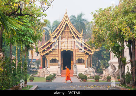 Un jeune moine marche dernières wihan lai kham au Wat Phra Singh, Chiang Mai, Thaïlande Banque D'Images