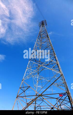 Un grand mât d'alimentation d'électricité à haute tension contre un ciel bleu Banque D'Images