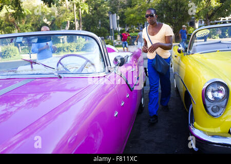 La Havane, Cuba. 29 Oct, 2015. Un homme passe entre classic de vieilles voitures qui font la queue pour la location à des touristes à Cuba La Havane, 29 octobre 2015. Les citoyens des États-Unis avec des permissions spéciales peuvent se rendre à Cuba. Les autorités cubaines sont en train de négocier avec les États-Unis sur des pourparlers de normalisation pour ouvrir Cuba aux États-Unis. Photo © Andre Andre oublier oublier/ZUMA/Alamy Fil Live News Banque D'Images