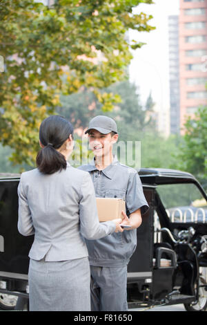 Young woman getting un paquet de livraison Banque D'Images